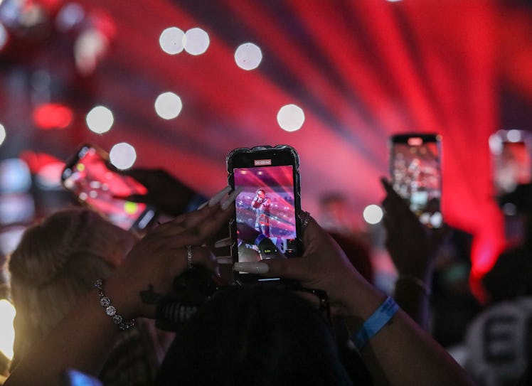 NEW ORLEANS, LOUISIANA - JUNE 15: Fans record onstage performances on iPhone during Vulture Island E...