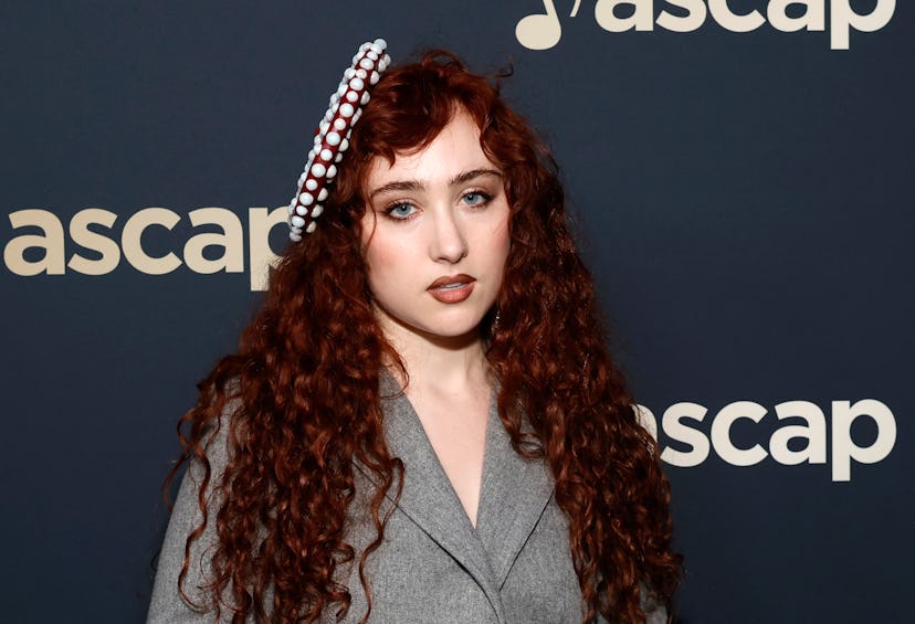 Woman with curly red hair wearing a gray blazer and decorative headband, posing at an ASCAP event.
