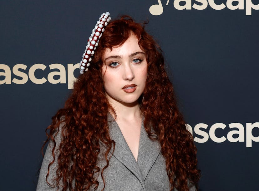 Woman with curly red hair wearing a gray blazer and decorative headband, posing at an ASCAP event.