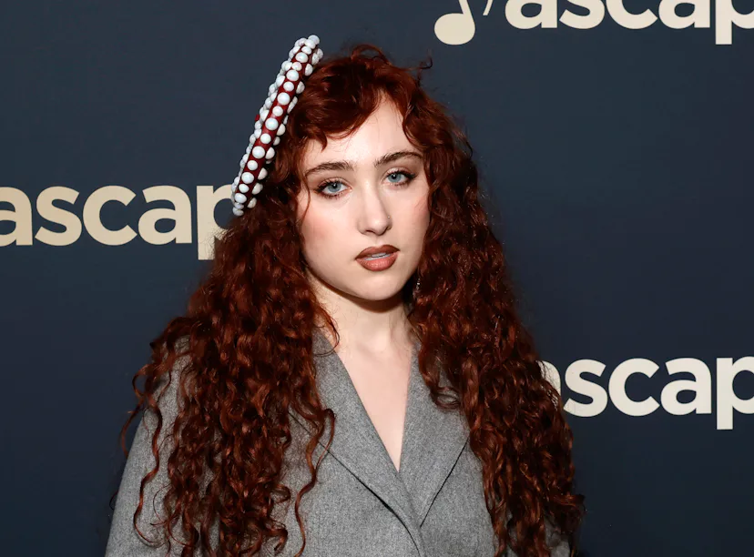 Woman with curly red hair wearing a gray blazer and decorative headband, posing at an ASCAP event.