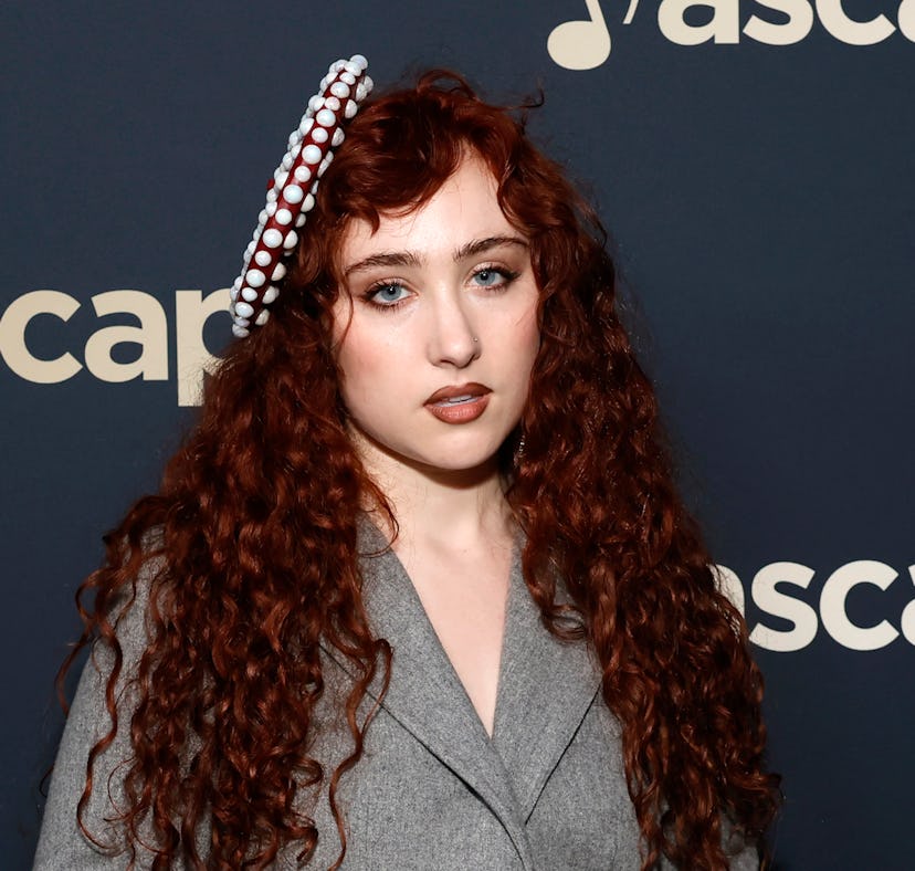 Woman with curly red hair wearing a gray blazer and decorative headband, posing at an ASCAP event.