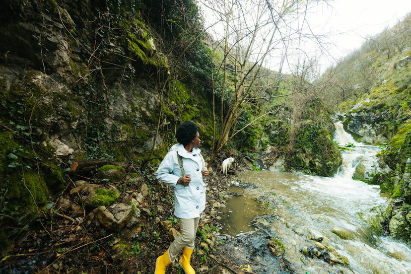 A young woman standing out in nature learning fun trivia about earth.