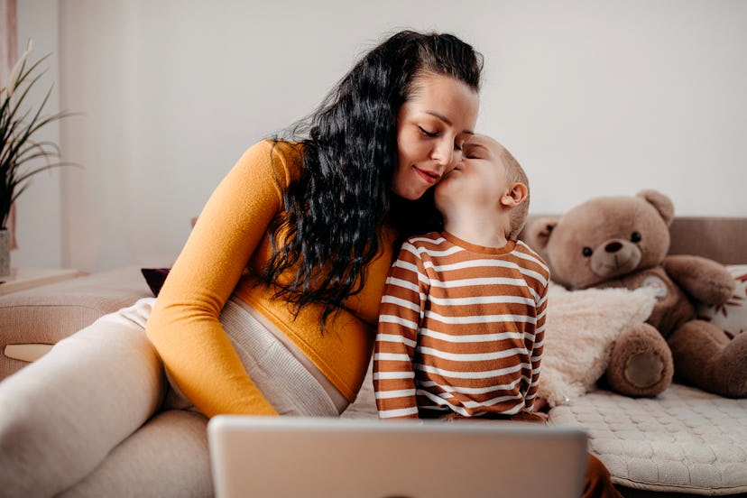 A young woman sits on the couch with her toddler and tells him fun facts for kids.