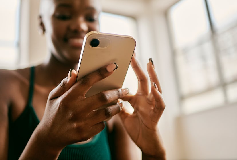 Close up of a woman holding her phone as she reads fun facts about social media.