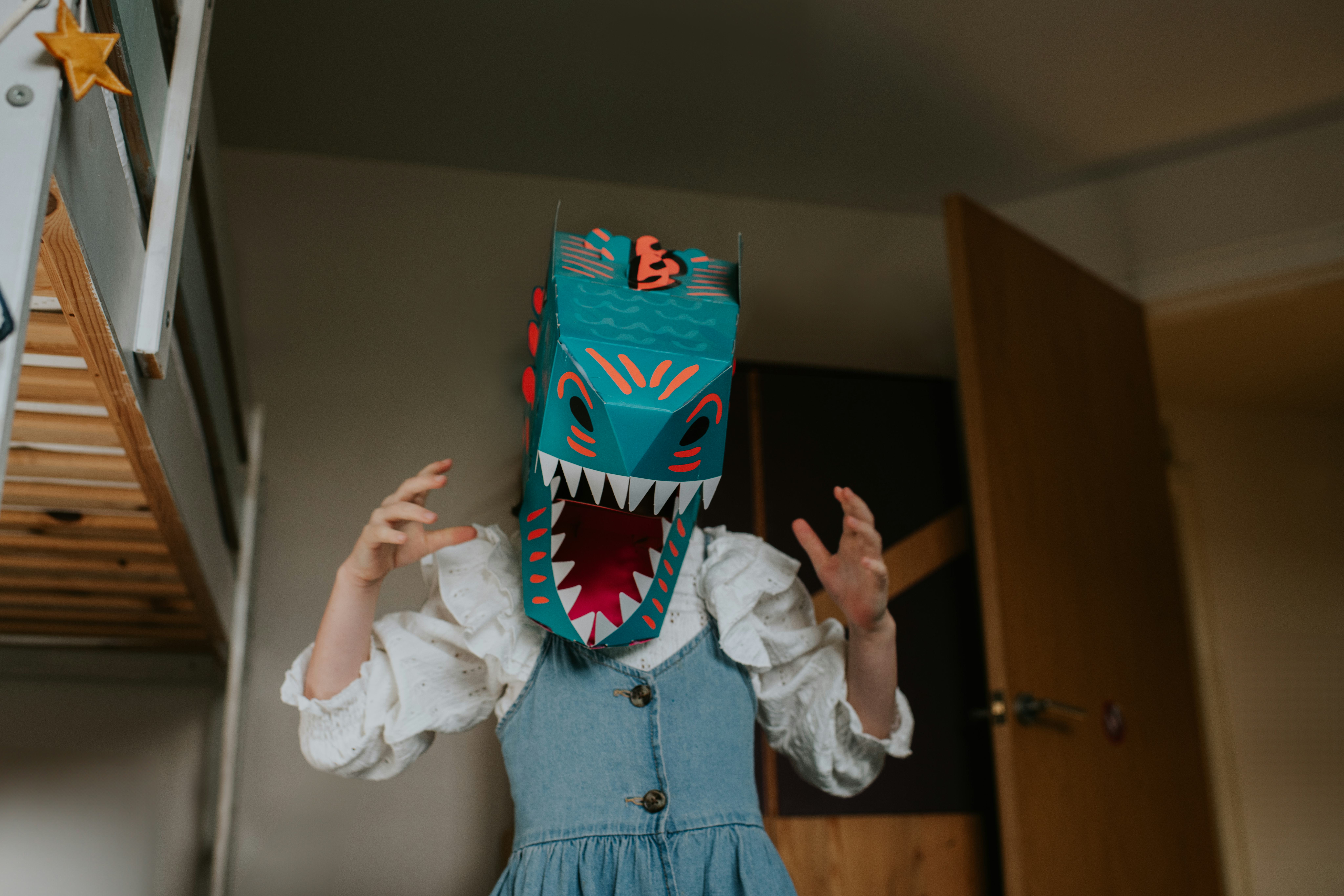 A child pretends to be a dinosaur in a blue din