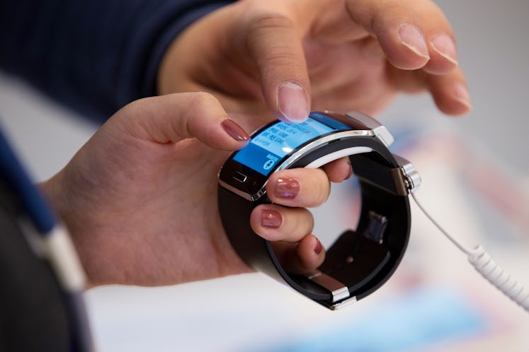 Attendees try out a Samsung Electronics Co. Galaxy Gear S smartwatch during the launch event for the...