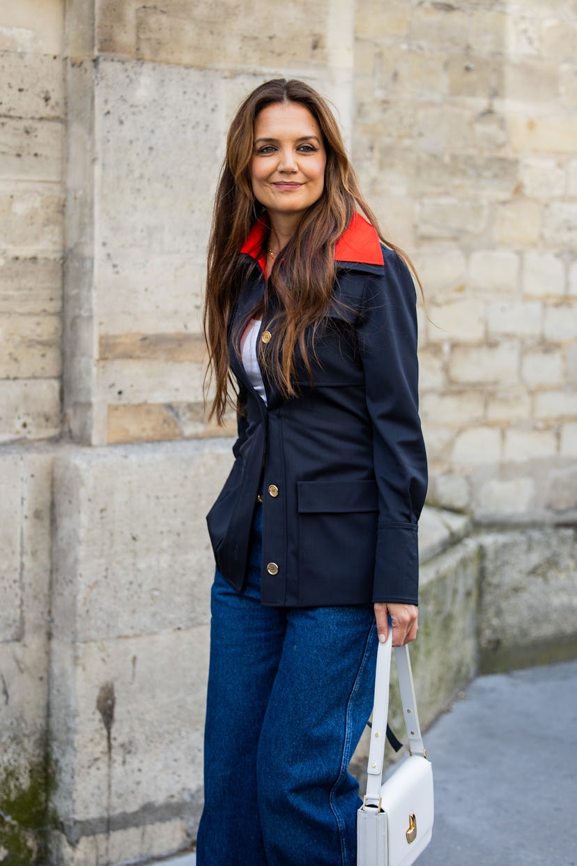 Katie Holmes wears navy red jacket, denim jeans, white bag outside Patou during the Haute Couture Fa...