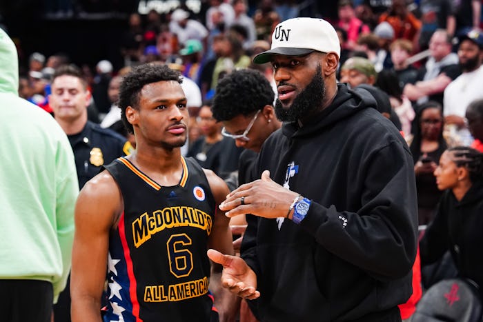 HOUSTON, TEXAS - MARCH 28: Bronny James #6 of the West team talks to Lebron James of the Los Angeles...