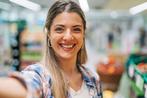 young woman buying groceries in supermarket