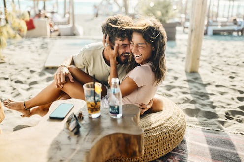 Young happy couple having fun in summer day on the beach.