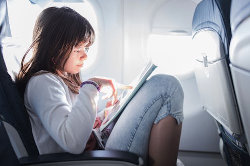 Teenage girl studying at an airplane