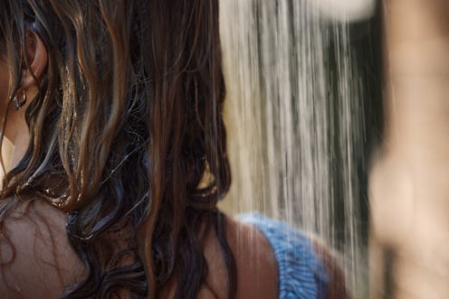 Close up of unrecognizable woman's hair under the shower outdoors.