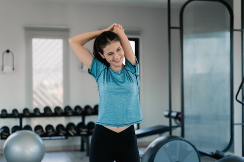 Female doing exercises to stretch her muscles in the gym.