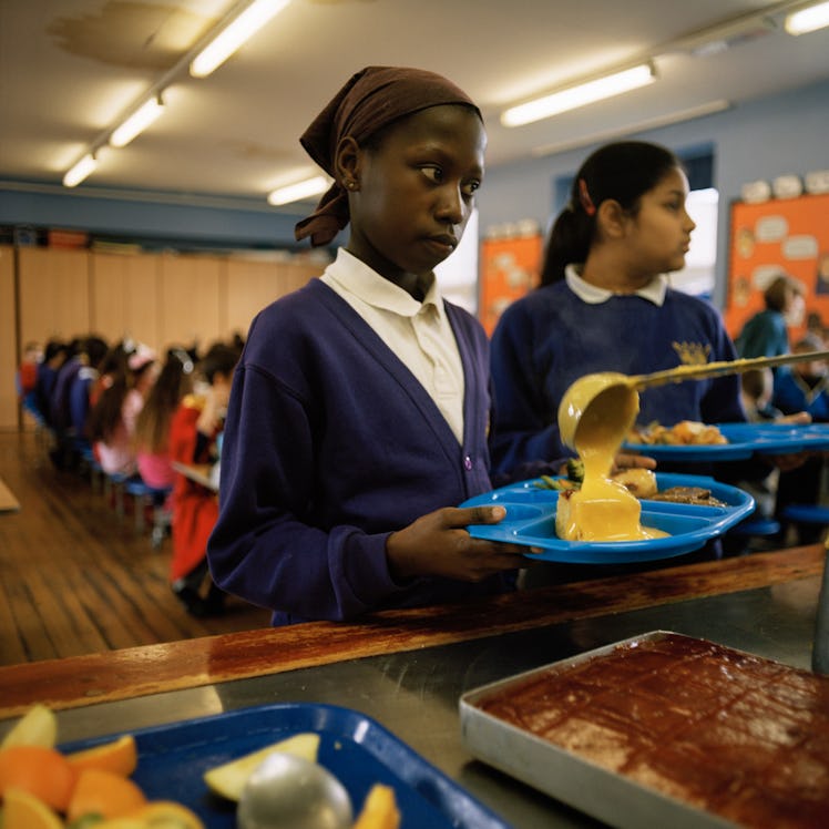 A pupil is served a large portion of custard on her pudding at the Kingsmead Primary School cafeteri...