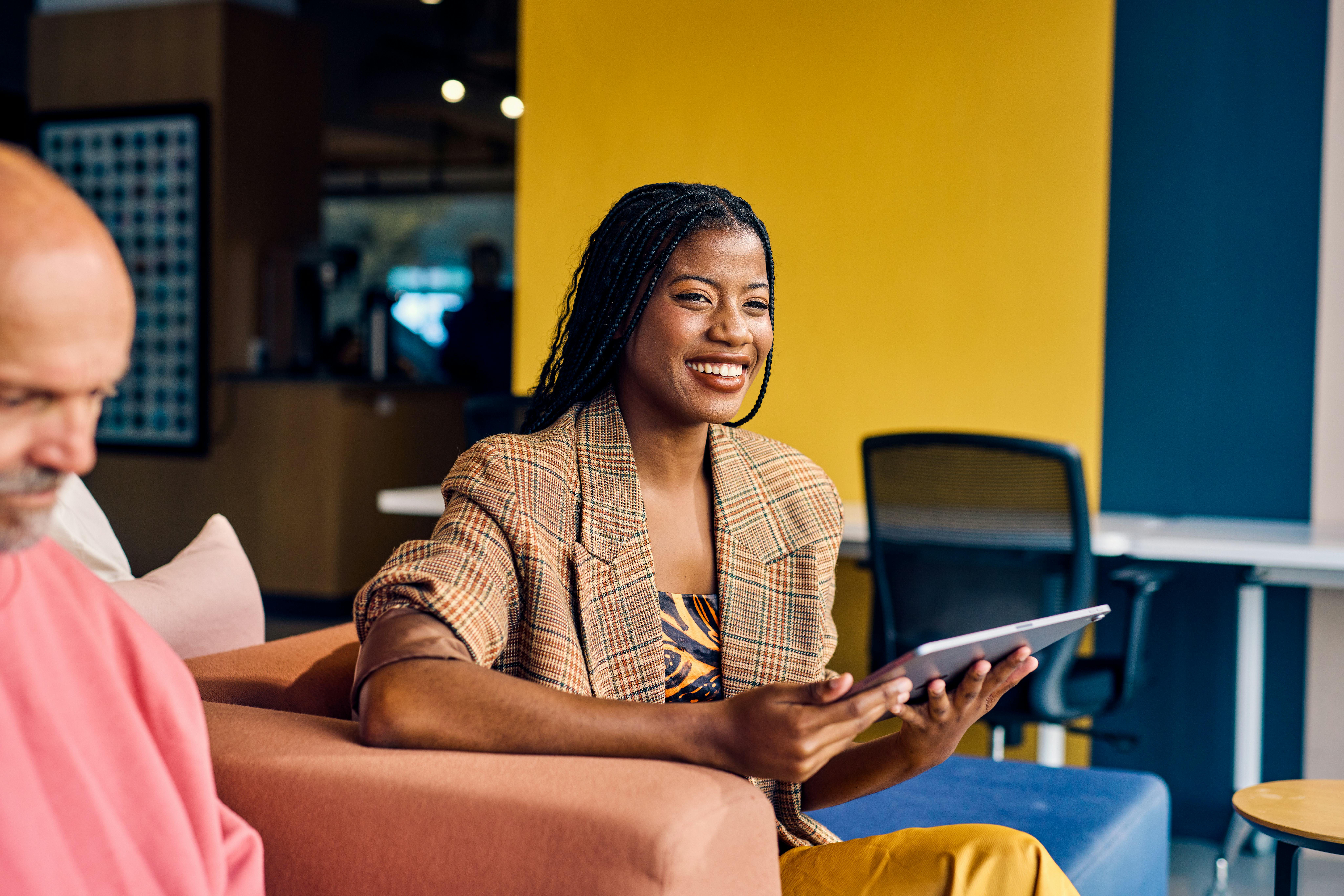 A woman smiling at an office meeting as everyone answers most likely to questions about work