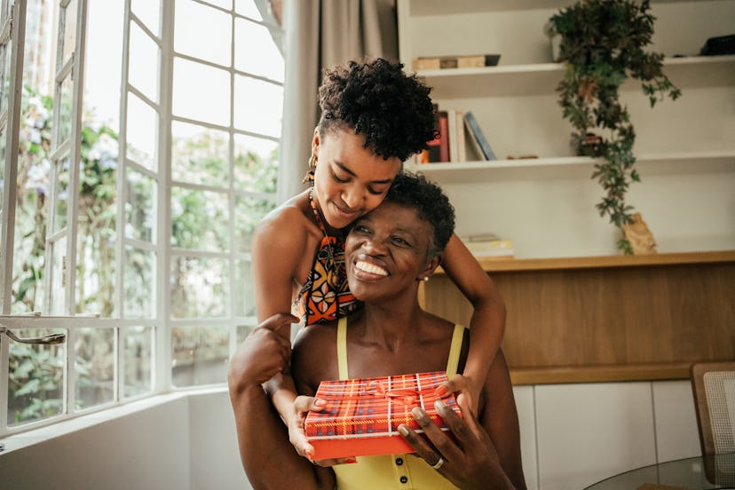Daughter giving her mom a gift after a round of most likely to questions about gifts