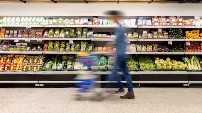 Man shopping at the supermarket pushing a shopping cart - blurred motion concepts
