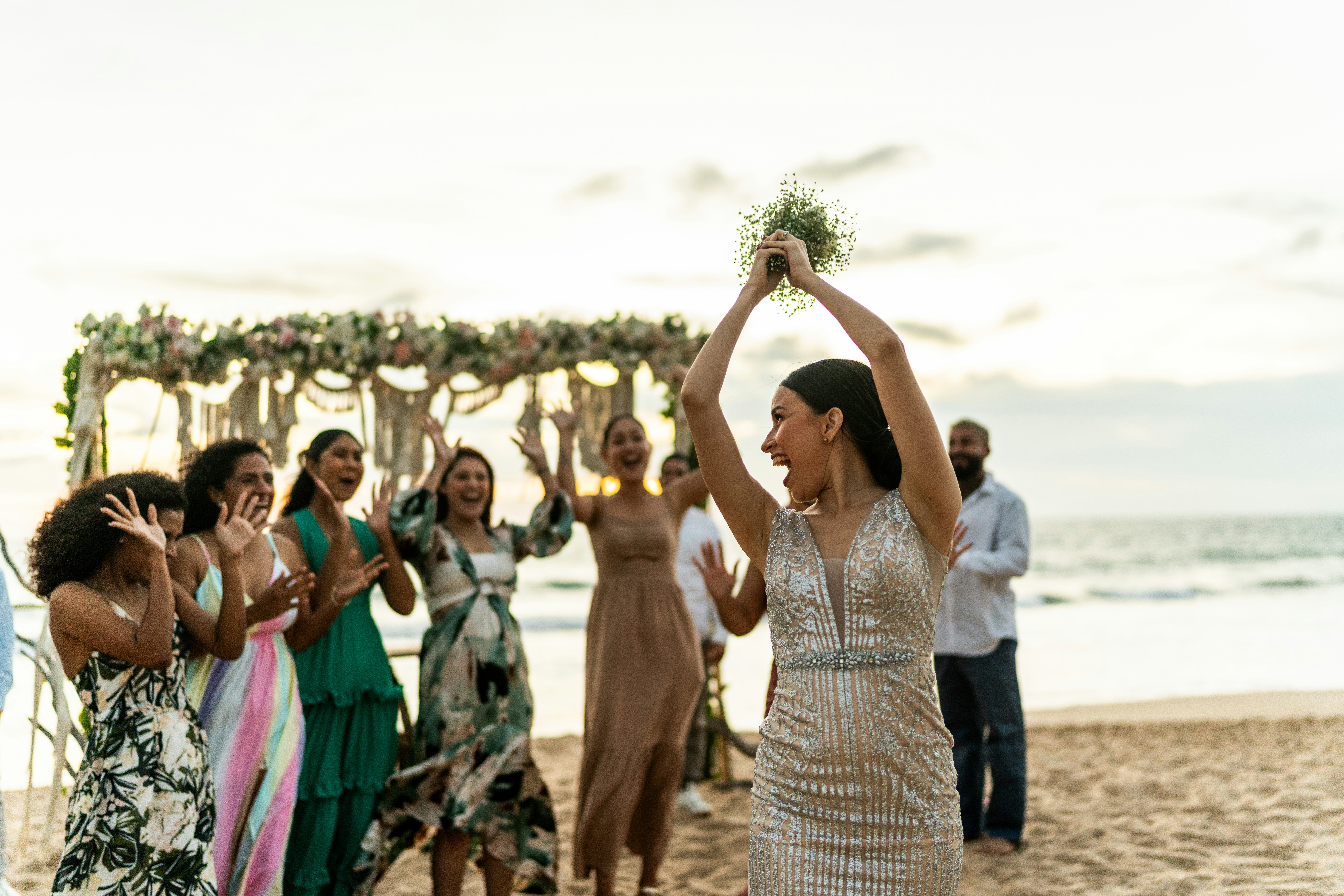 A bride tossing her wedding bouquet and laughing at wedding-related most likely to questions
