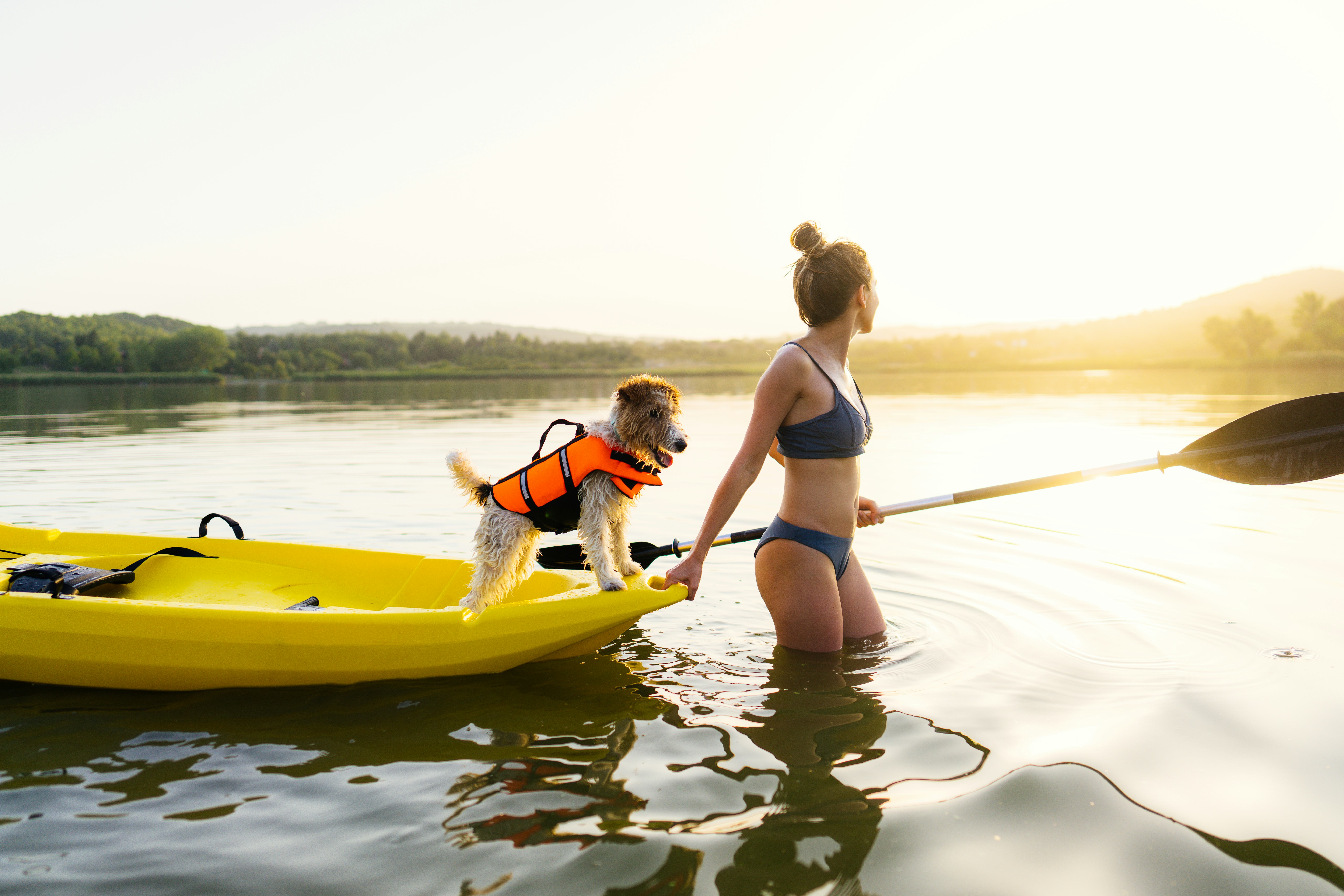 A woman towing her dog in a boat in a lake thinking of good water-related most likely to questions t&hellip;