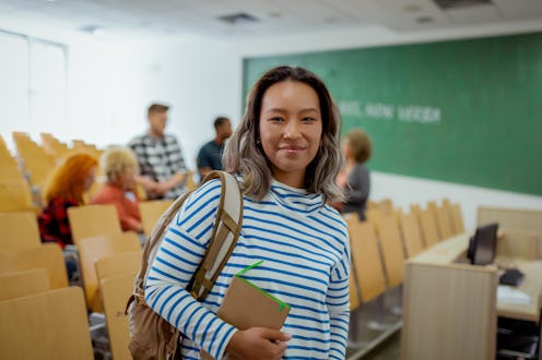 Portrait of Pretty Asian Gen Z Female College Student Looking at Camera While Standing in Classroom ...