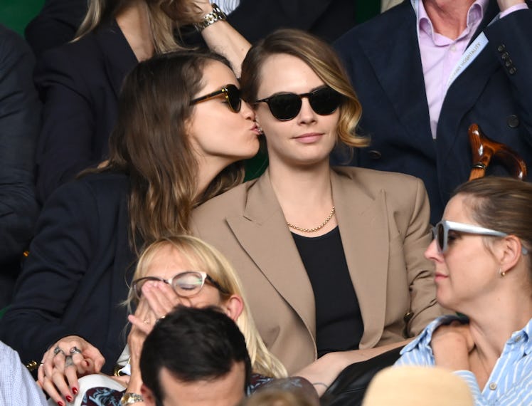 Minke and Cara Delevingne kiss as they attend day eight of the Wimbledon Tennis Championships at All...