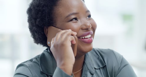 Happy African woman answering a phone call in an office on blur background. Beautiful businesswoman ...