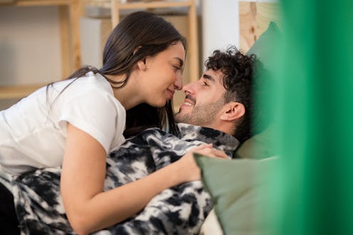 Couple enjoying a passionate moment in their bedroom bed, enjoying every stage of the relationship.