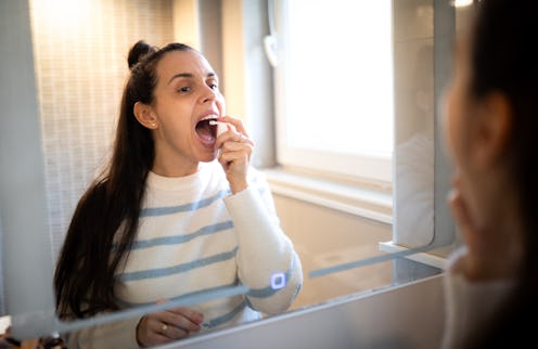 the woman sprays the spray down her throat