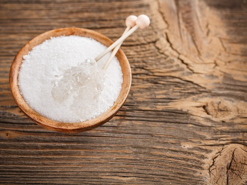 Xylitol in wooden bowl with candy sugar on sticks