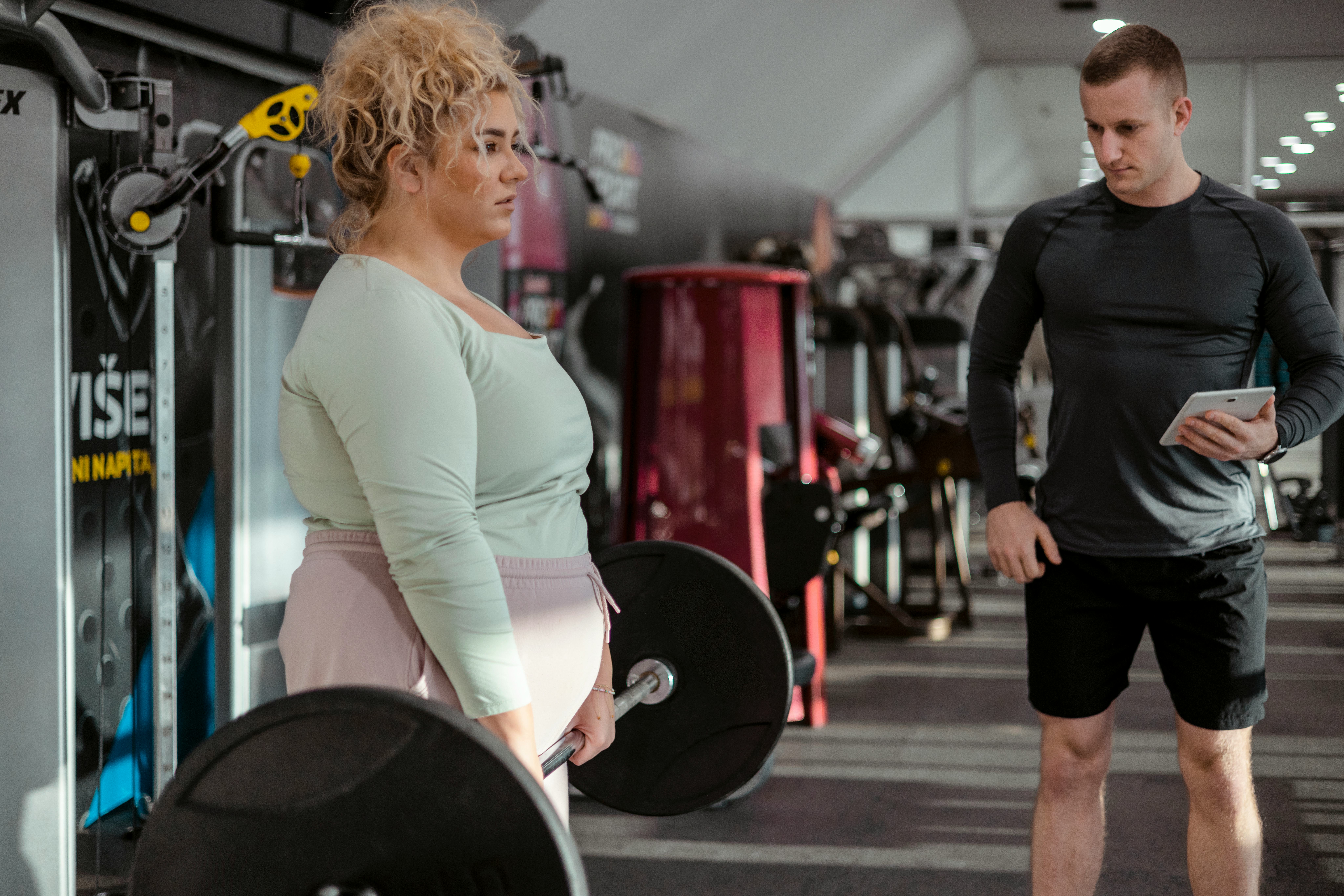 Concept of Weight Loss. Plus Size Woman in Sportswear Doing Weight Exercises With Assistance of Her &hellip;