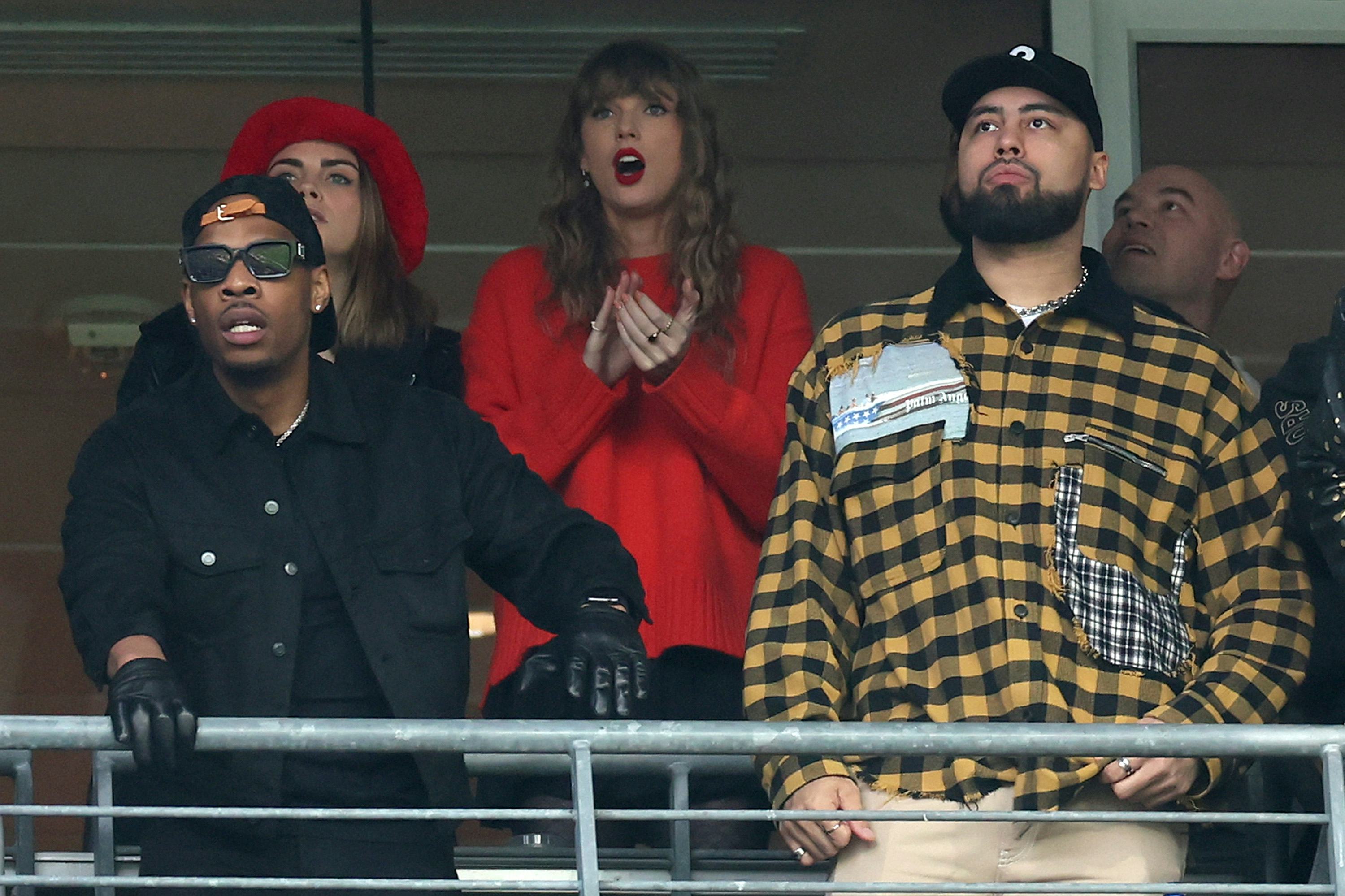 Cara Delevingne, Taylor Swift and Ross Travis look on during the second quarter in the AFC Champions&hellip;