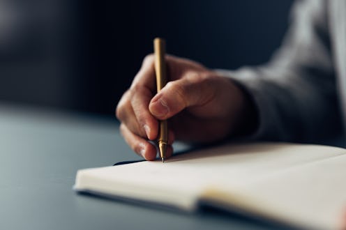 An individual meticulously jotting down notes in a notebook using an elegant pen, with a close-up on...