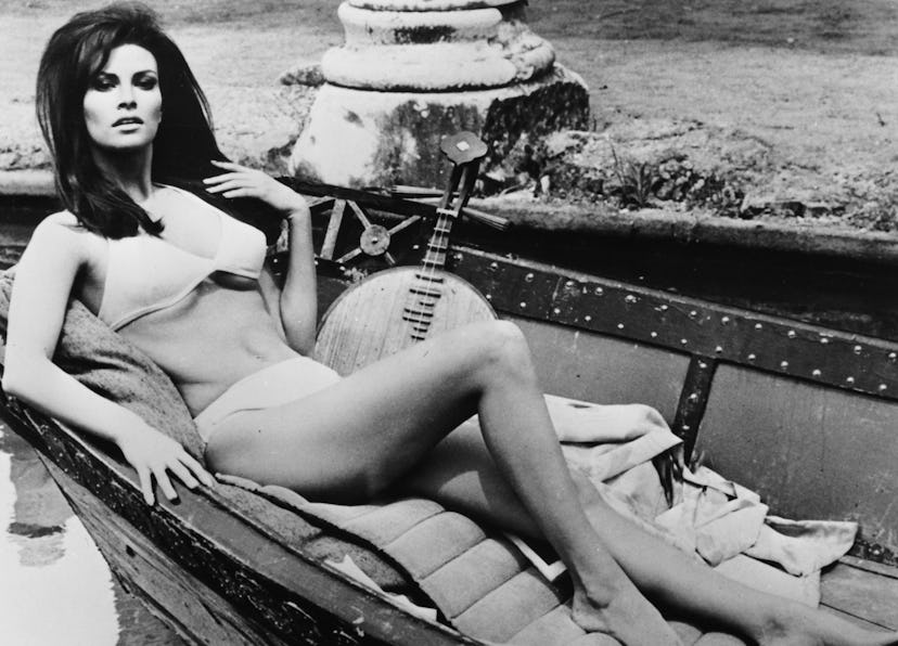 Portrait of actress Raquel Welch lying in a boat wearing a bathing suit, as she appears in the film …