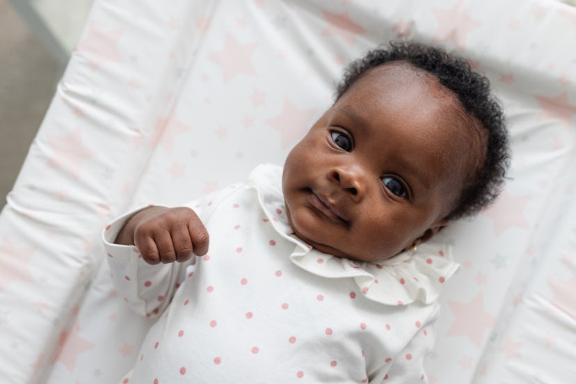 newborn baby girl laying.jpg?w=414&h=276&fit=crop&crop=focalpoint&dpr=2&fp x=0.5871&fp y=0 Newborn baby girl laying on a changing mat looking up at the camera