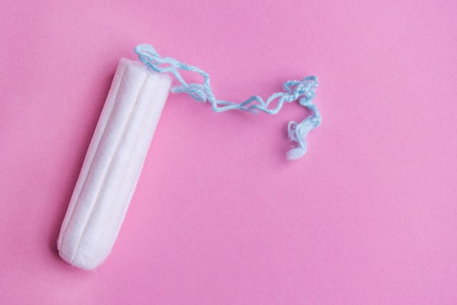 Tampon on pink background. A new study has found that tampon products contain a variety of heavy met...