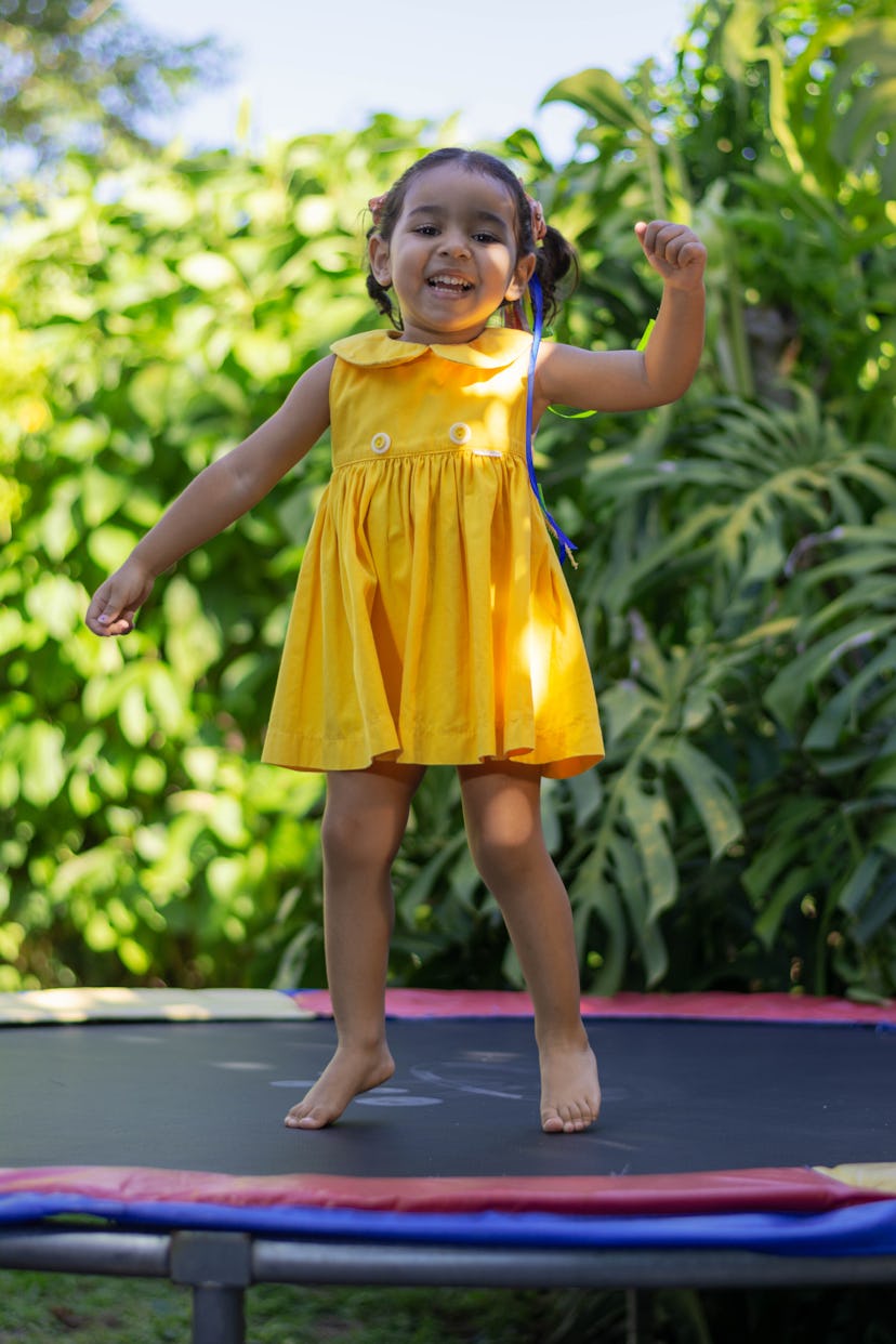 portrait of a happy.jpg?w=414&h=621&fit=crop&crop=focalpoint&dpr=2&fp x=0.4975&fp y=0 happy little girl playing in the yard in her yellow dress.