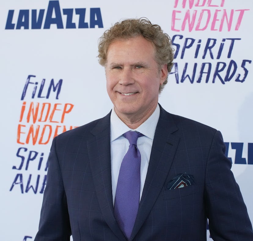 A man in a blue suit with a light blue shirt and patterned tie smiles at a Film Independent Spirit A...