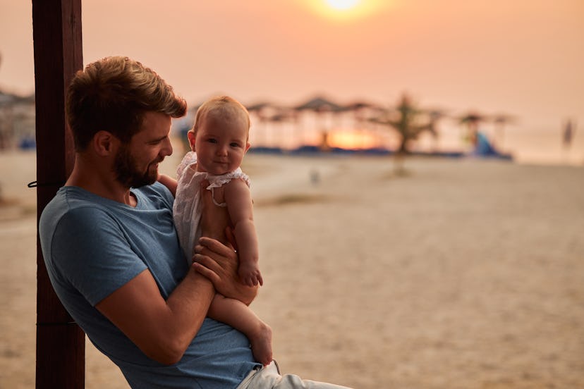 young father baby enjoying.jpg?w=414&h=276&fit=crop&crop=focalpoint&dpr=2&fp x=0.3902&fp y=0 Young father and baby enjoying a tropical paradise beach during sunset.