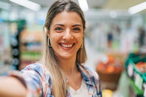 young woman buying groceries in supermarket