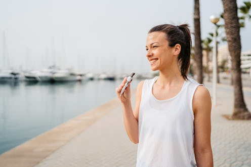 Young Woman eating a protein bar after training on the quayside in Palma de Mallorca in Spain.