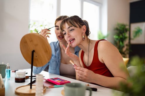 Girlfriends doing make-up at home.