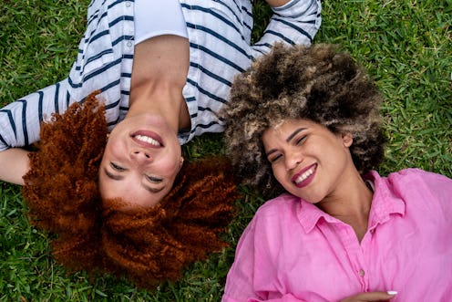 Portrait of young women lying on grass outdoors