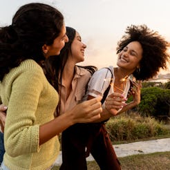 Happy young friends playing with sparkles outdoors