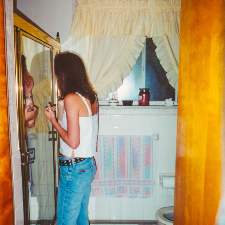 A mom when she was young in the 1990. Getting dressed to go out to a party.