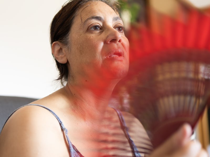 Middle Eastern mature adult woman dizzy suffering from high temperatures. image with motion blur. lo...