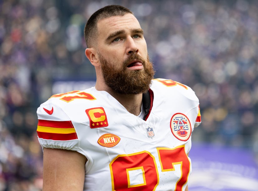 Close-up of a focused American football player in a white and red jersey, with the number 87 and a c...