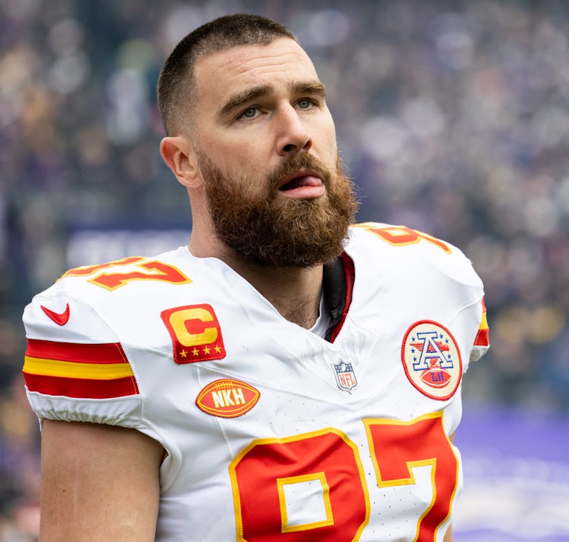Close-up of a focused American football player in a white and red jersey, with the number 87 and a c...