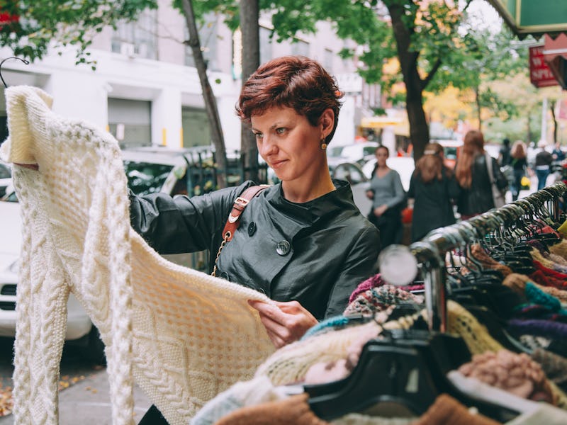 Woman looking at clothing in thrift store