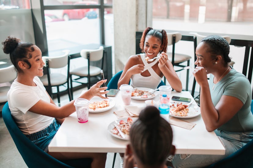 A mother and her three daughters have fun eating a brunch of specialty waffles