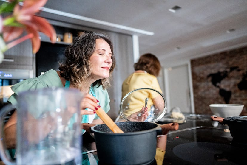 Woman smelling food in kitchen